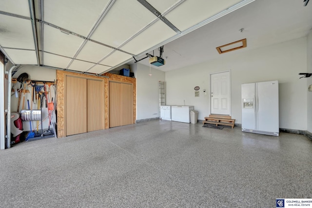 garage with white refrigerator with ice dispenser, a garage door opener, and baseboards