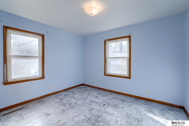 empty room featuring visible vents and baseboards