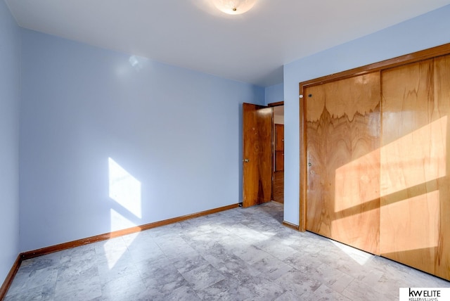 unfurnished bedroom with a closet and baseboards