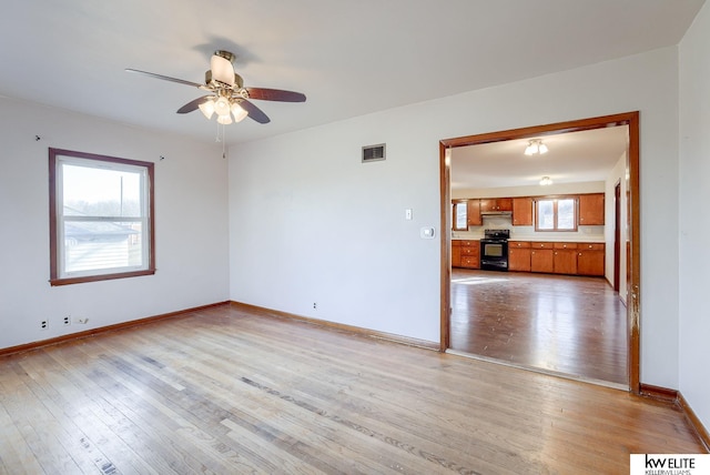 unfurnished living room featuring visible vents, baseboards, light wood-style flooring, and a ceiling fan