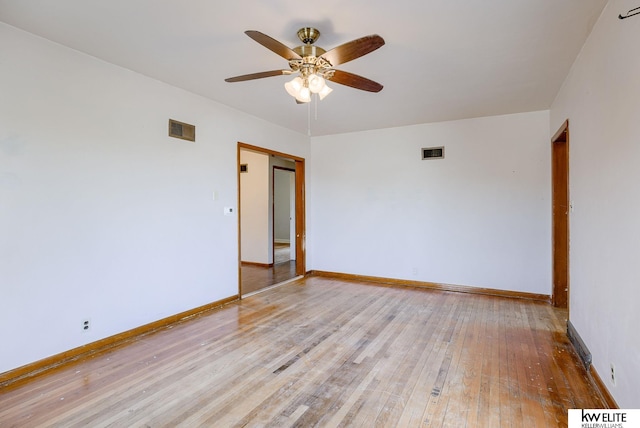 empty room with visible vents, light wood-style flooring, a ceiling fan, and baseboards