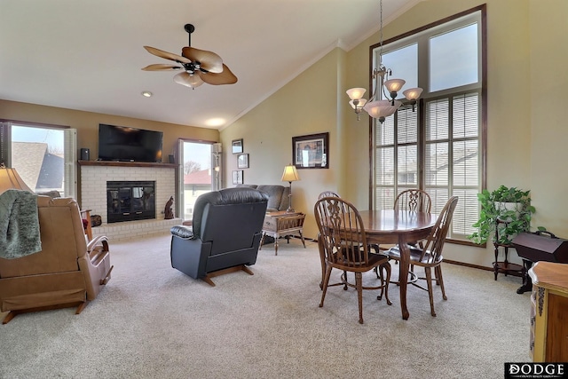 dining room featuring light carpet, a brick fireplace, crown molding, and a wealth of natural light