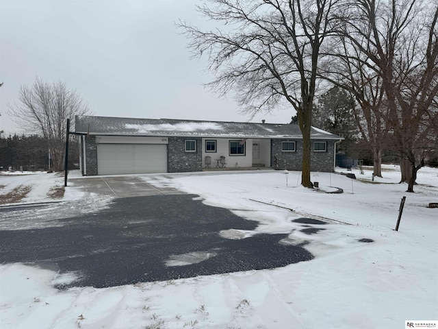 ranch-style home with brick siding, a garage, and driveway