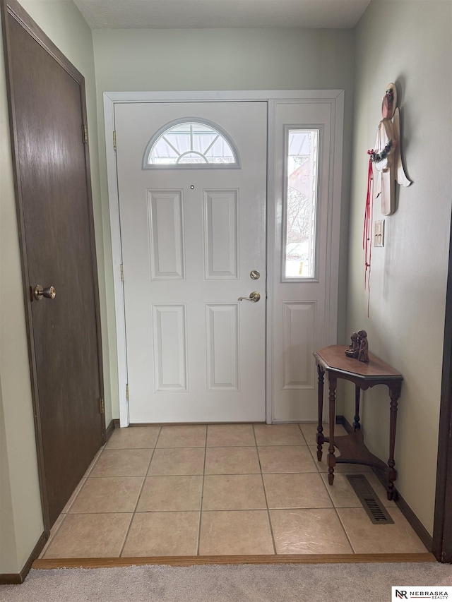 foyer featuring light tile patterned floors and baseboards