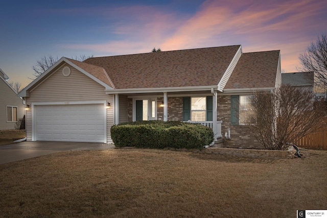 ranch-style house with brick siding, a front lawn, covered porch, a garage, and driveway