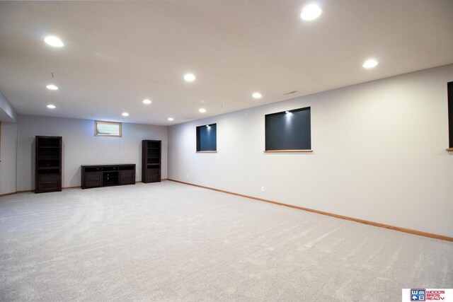 below grade area with recessed lighting, light colored carpet, and baseboards