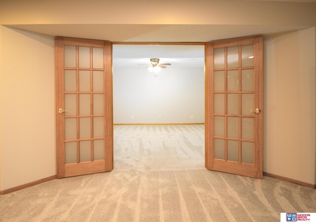 carpeted empty room featuring baseboards and ceiling fan