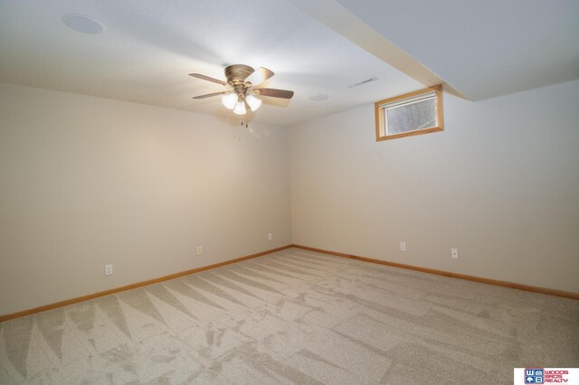 carpeted spare room featuring visible vents, ceiling fan, and baseboards