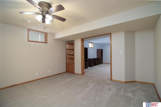 basement featuring a wealth of natural light, baseboards, and light carpet