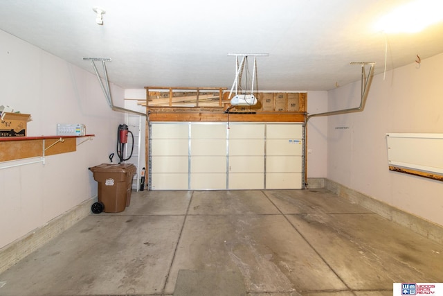 garage featuring a garage door opener and baseboards