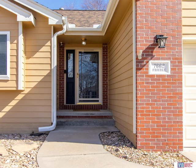 entrance to property with brick siding and roof with shingles