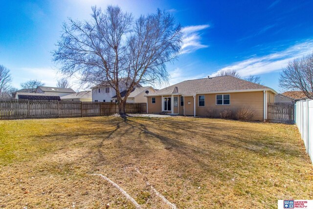 rear view of property with a patio, a fenced backyard, and a lawn