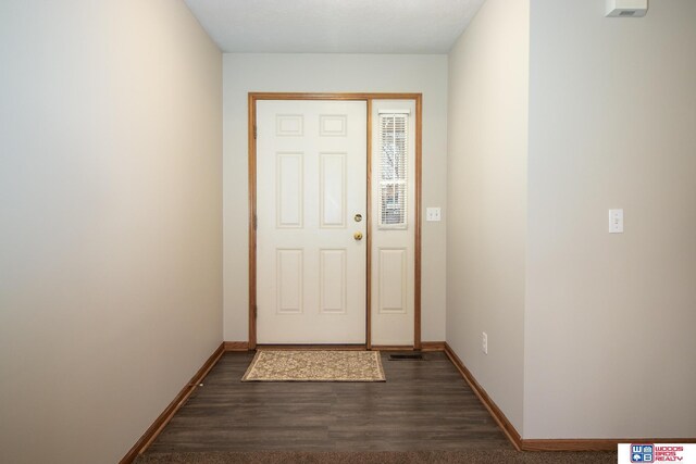 entryway featuring baseboards and dark wood-style flooring