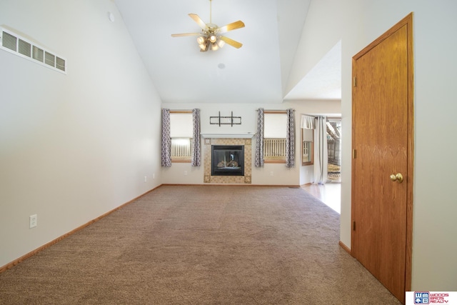 unfurnished living room with visible vents, high vaulted ceiling, a ceiling fan, a glass covered fireplace, and carpet floors