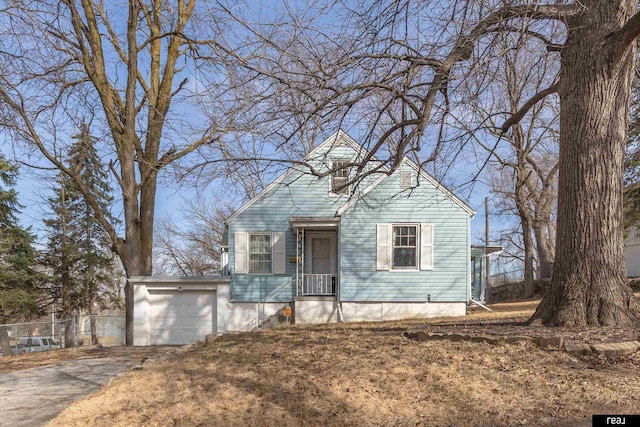 view of front facade featuring aphalt driveway, an attached garage, and fence