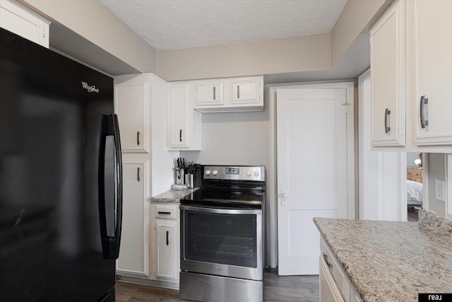 kitchen with white cabinets, stainless steel electric range, dark wood-style flooring, and freestanding refrigerator