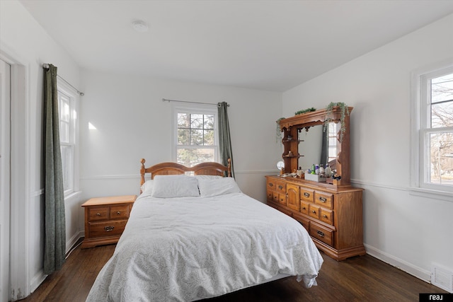 bedroom featuring dark wood-type flooring, multiple windows, baseboards, and visible vents