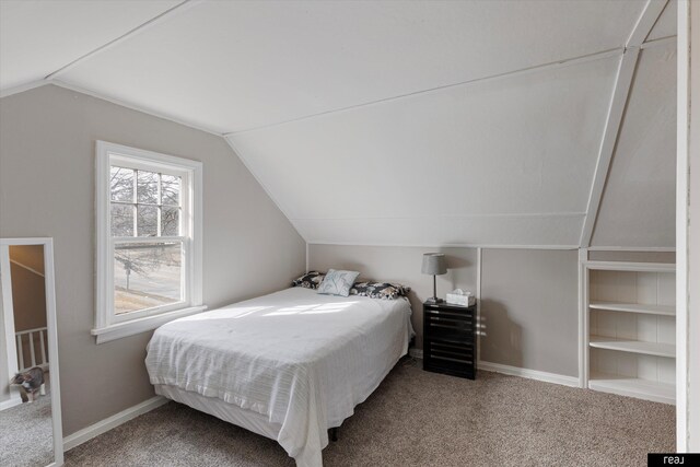 bedroom featuring baseboards, lofted ceiling, and carpet flooring