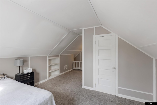 unfurnished bedroom featuring baseboards, visible vents, carpet floors, and lofted ceiling