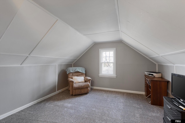 living area featuring vaulted ceiling, baseboards, and carpet floors