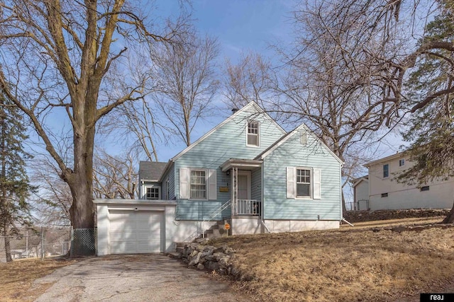 view of front facade with fence, a garage, and driveway