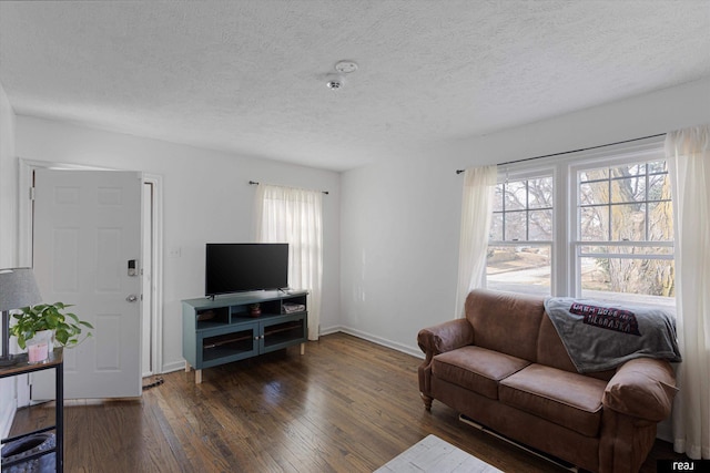 living room with baseboards, a textured ceiling, a healthy amount of sunlight, and hardwood / wood-style floors