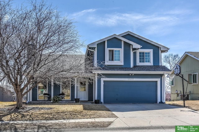 traditional-style home with covered porch, roof with shingles, concrete driveway, an attached garage, and central AC unit