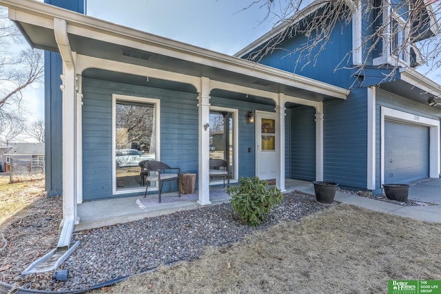 view of exterior entry with a porch and an attached garage