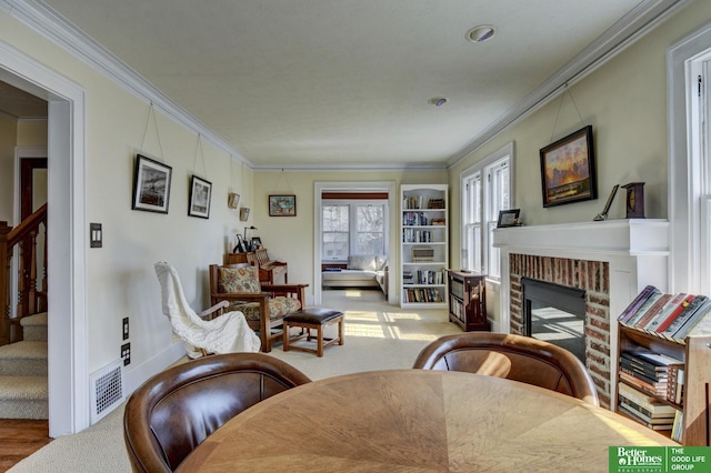 interior space featuring visible vents, a brick fireplace, baseboards, stairs, and ornamental molding