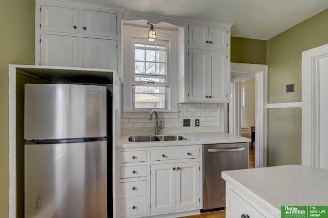 kitchen with a sink, white cabinetry, appliances with stainless steel finishes, and light countertops