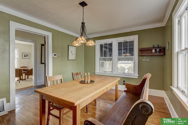 dining area featuring visible vents, ornamental molding, baseboards, and hardwood / wood-style floors