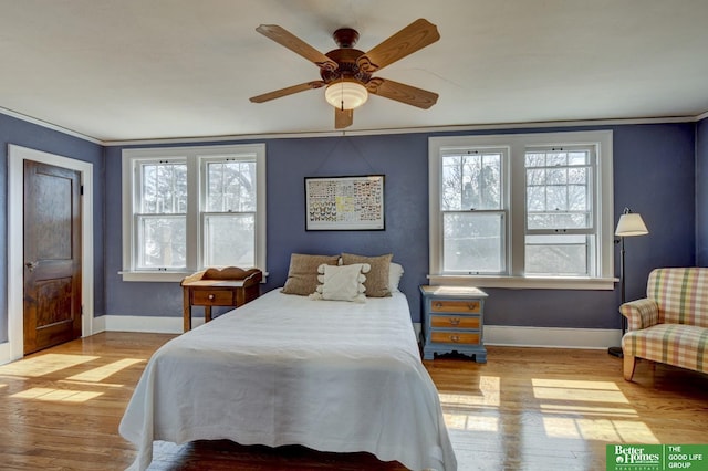 bedroom with crown molding, baseboards, and wood finished floors