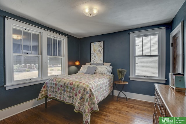 bedroom with wood finished floors and baseboards