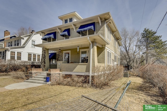 view of front facade with stucco siding, a porch, and central AC