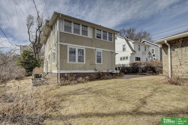 back of house featuring a yard and stucco siding