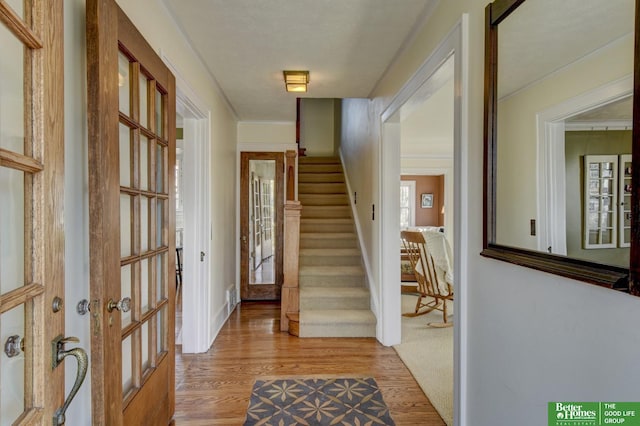 foyer entrance featuring visible vents, baseboards, wood finished floors, and stairs