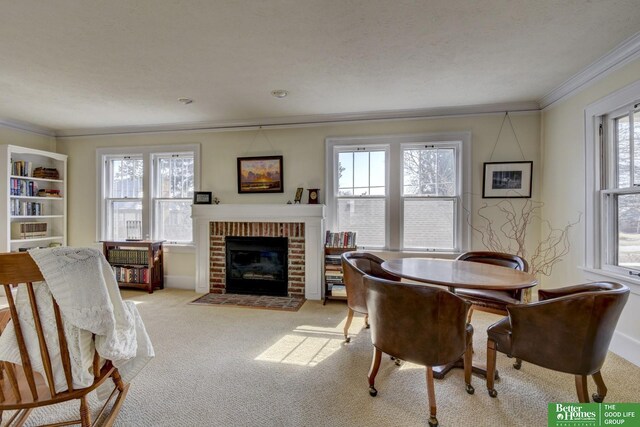 dining space with light colored carpet, a fireplace, and crown molding