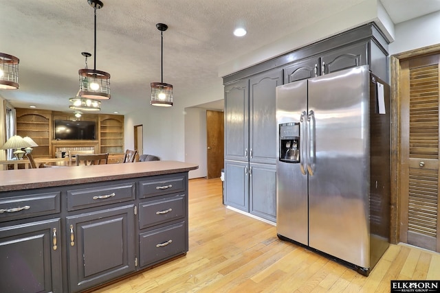 kitchen featuring light wood-type flooring, pendant lighting, gray cabinets, a textured ceiling, and stainless steel fridge with ice dispenser