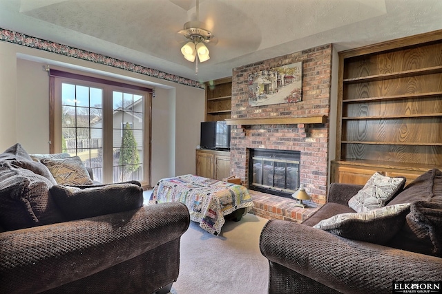 carpeted living room featuring a brick fireplace, built in features, and a textured ceiling