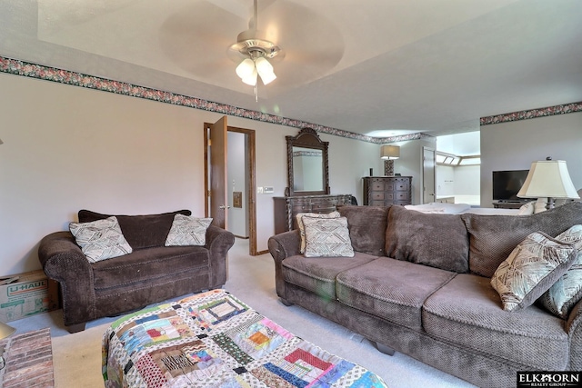 carpeted living area featuring a ceiling fan