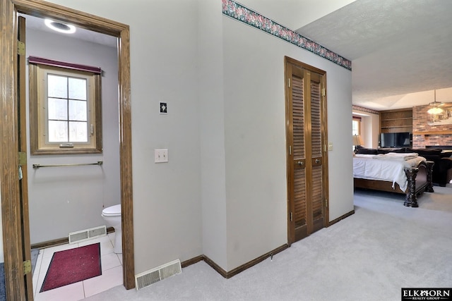 hallway featuring visible vents, baseboards, and carpet floors