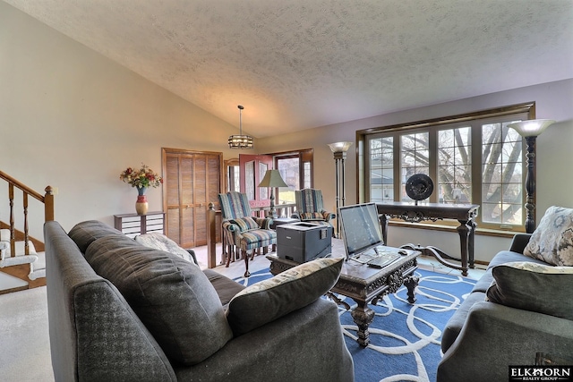 living room with stairs, vaulted ceiling, and a textured ceiling