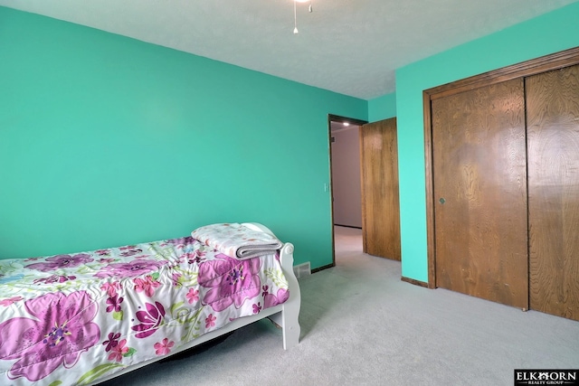 bedroom featuring carpet flooring, baseboards, and a closet