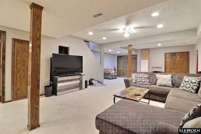 carpeted living area with recessed lighting, visible vents, a textured ceiling, and decorative columns