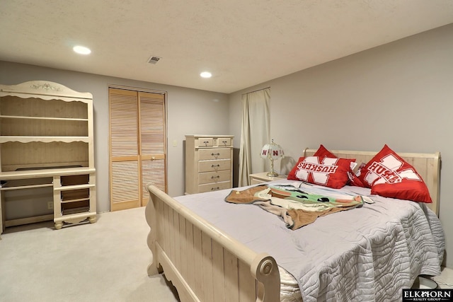 carpeted bedroom featuring recessed lighting, visible vents, and a closet