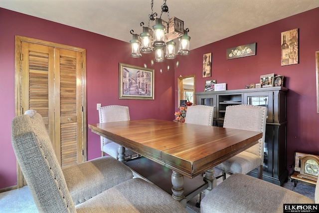 dining space with a chandelier and an accent wall