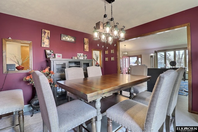 dining space featuring an accent wall and baseboards