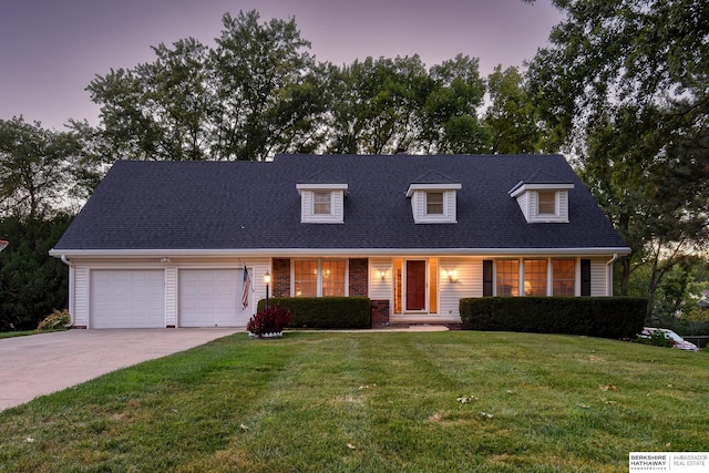 cape cod home with brick siding, a shingled roof, concrete driveway, a garage, and a yard