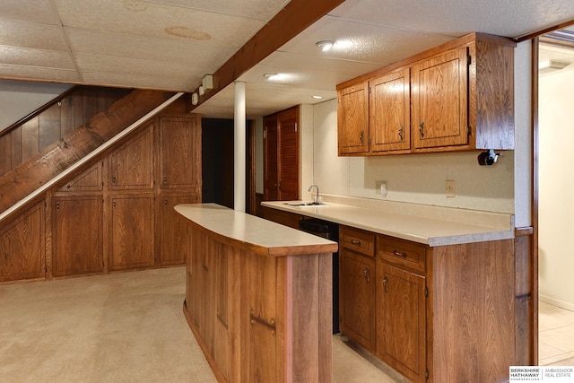 kitchen featuring a sink, brown cabinets, a center island, and light countertops