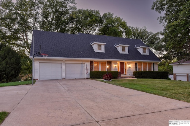 cape cod house with a front lawn, a garage, driveway, and roof with shingles